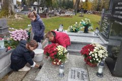 Uczniowie porządkujący  groby na cmentarzu w Pławnie.