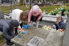 Uczniowie porządkujący  groby na cmentarzu w Pławnie.